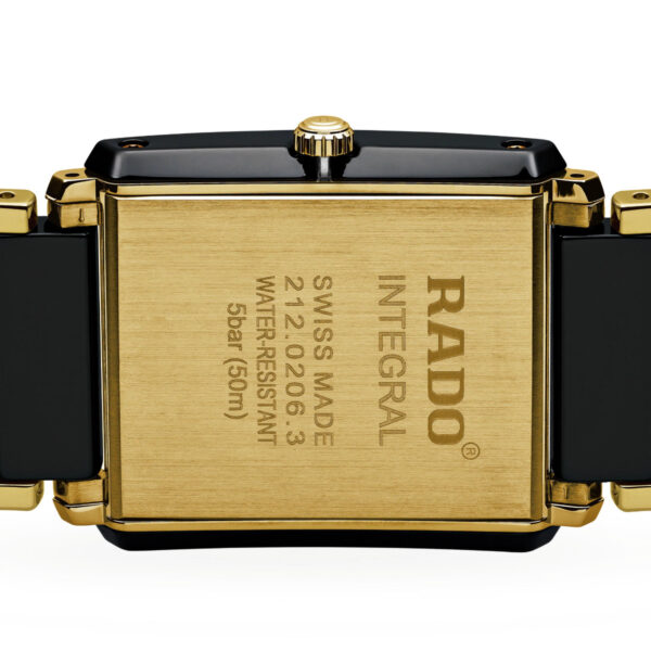 Nahaufnahme der Rückseite einer Rado Integral Diamonds-Uhr mit einem rechteckigen Gehäuse in Goldfarbe und eingraviertem Text: „RADO INTEGRAL SWISS MADE 212.0355.3 WASSERDICHT 5 bar (50 m)“. Sie hat ein schwarzes und goldenes Gliederarmband.