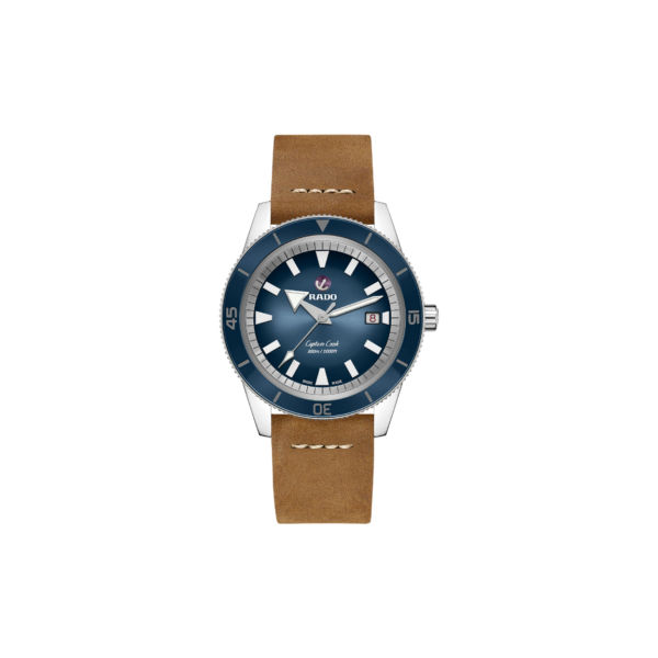 Die Rado Captain Cook Automatic verfügt über ein braunes Lederarmband mit weißen Nähten, ein silbernes Gehäuse und ein blaues Zifferblatt mit einem Datumsfenster bei 3 Uhr. Es hat weiße Stundenmarkierungen und Zeiger sowie einen roten Sekundenzeiger.