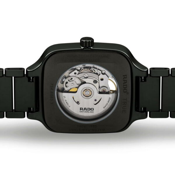 Das Bild zeigt die Rückseite der Rado True Square Automatic Open Heart-Armbanduhr und hebt ein transparentes Gehäuse hervor, das die komplexen mechanischen Uhrwerke offenbart. Die Uhr besticht durch ein dunkles, elegantes Design mit einem Metallarmband.