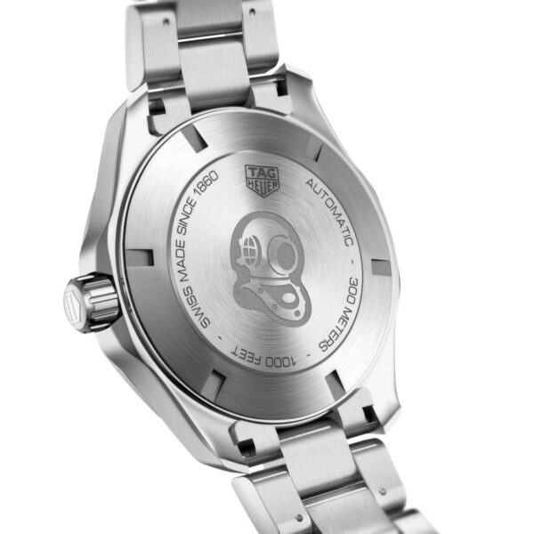 Nahaufnahme der Rückseite einer TAG Heuer Aquaracer Cal. 7 GMT Uhr mit eingraviertem Taucherhelm-Logo. Der Text lautet „Swiss Made Since 1860“, „Automatic“, „300 Meters“ und „1000 Feet“. Das Armband und Gehäuse sind aus Edelstahl.