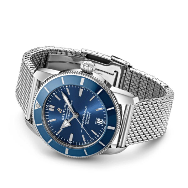 Die Breitling Superocean Heritage B20 42 ist eine silberne Armbanduhr mit blauem Zifferblatt und blauer Lünette, Datumsanzeige und Edelstahlarmband. Die kontrastierenden Zeiger und Stundenmarkierungen sorgen für klare Sicht auf dem blauen Hintergrund.