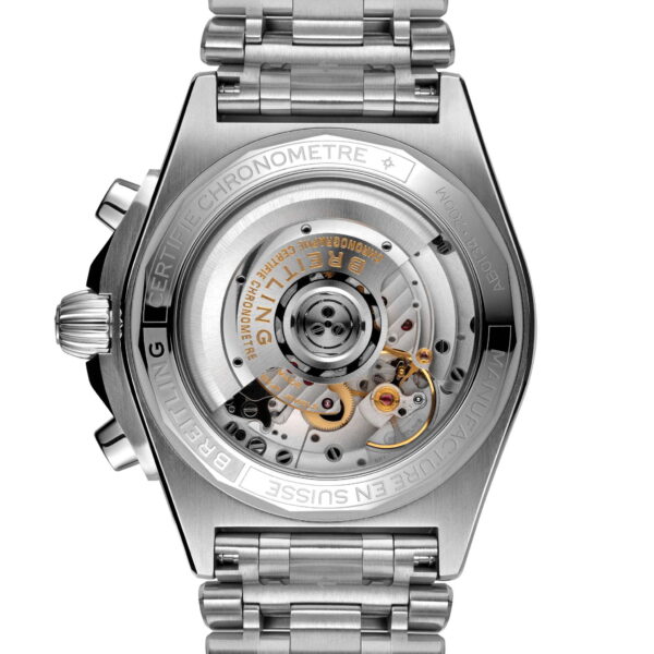 Der Breitling Chronomat B01 42 besticht durch einen transparenten Gehäuseboden, der den Blick auf das komplexe mechanische Uhrwerk freigibt. Das Metallarmband ist befestigt und trägt die Gravur „CERTIFIE CHRONOMETRE“ und weitere Details.