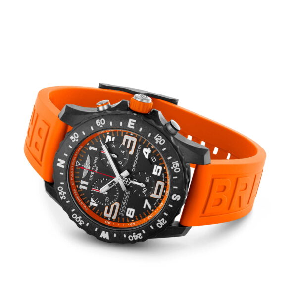 Die Breitling Endurance Pro ist eine robuste Armbanduhr mit einem schwarzen Zifferblatt mit orangefarbenen Ziffern, einem kräftigen orangefarbenen Armband mit der Prägung „BR“, weißen Minutenmarkierungen auf der Lünette, mehreren Hilfszifferblättern und einer Datumsanzeige.