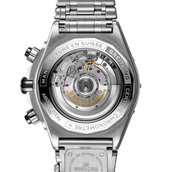 Das Bild zeigt die Rückansicht einer Breitling Super Chronomat B01 44 und hebt ihr komplexes mechanisches Uhrwerk hervor. Gehäuse und Armband aus Edelstahl sind ebenso sichtbar wie Gravuren und der Markenname auf der Schwungmasse.