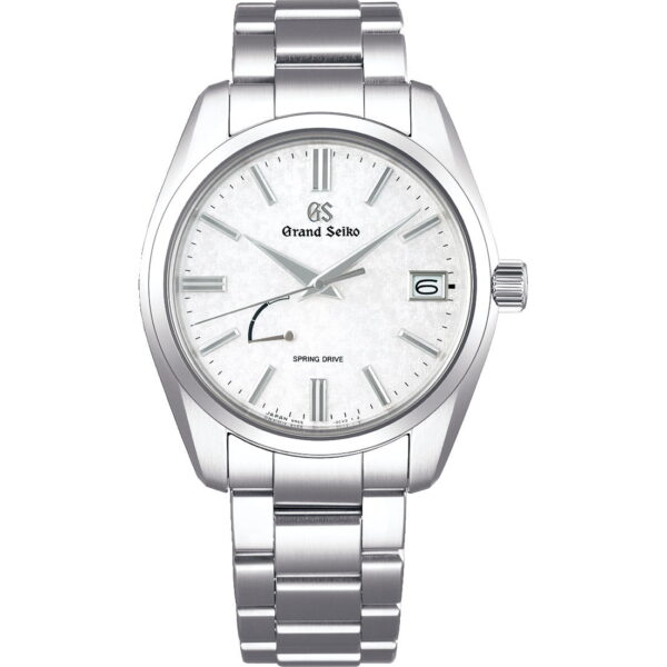 Die Grand Seiko Heritage verfügt über ein silbernes Metallarmband, ein weißes, strukturiertes Zifferblatt, silberne Indexe und Zeiger, ein Datumsfenster bei 3 Uhr sowie eine Gangreserveanzeige oberhalb von 8 Uhr.