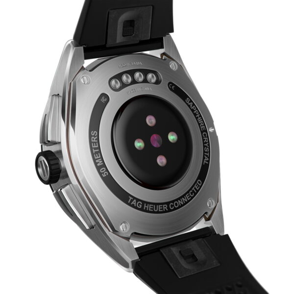 Rückansicht einer TAG Heuer Connected Calibre E4 in Silber mit Herzfrequenzsensor und Gravur „50 Meter Wasserdichtigkeit“. Mit schwarzem Kautschukarmband und sichtbarem Gehäuseboden mit Schrauben.