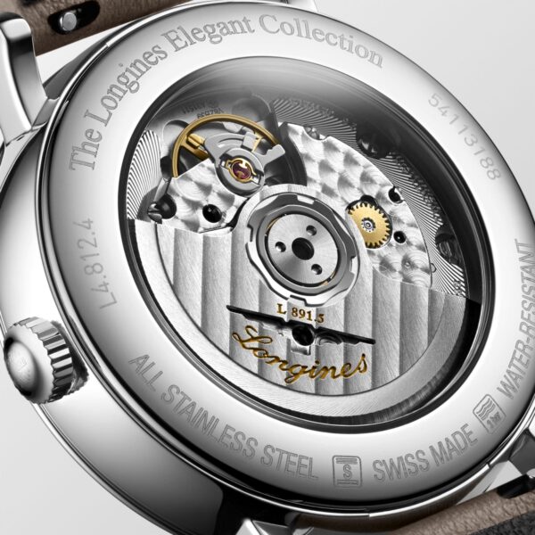 Die Nahaufnahme der Rückseite einer Longines-Uhr offenbart filigrane Zahnräder und das Markenlogo. Das Metallgehäuse ist mit der Gravur „The Longines Elegant Collection“ und den Spezifikationen versehen und unterstreicht so das luxuriöse, detailreiche Design.