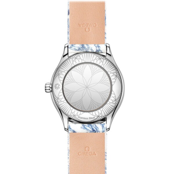 Das Bild zeigt die Rückseite einer OMEGA De Ville Trésor Armbanduhr mit floralem Muster auf dem silbernen Gehäuse und einem marmorierten Armband in Beige- und Blautönen. „Stainless Steel“ und Markendetails sind auf der Rückseite eingraviert.