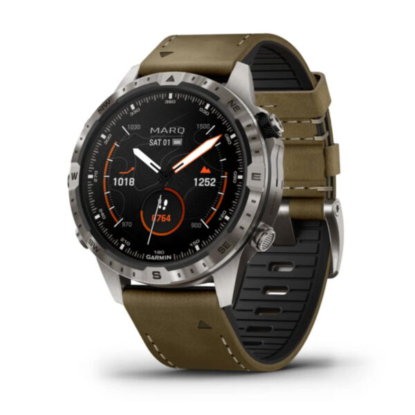 Die Garmin Marq Adventurer 2.Gen. ist eine moderne Smartwatch mit rundem Zifferblatt, das Uhrzeit, Datum und Details in Orange und Weiß anzeigt. Sie verfügt über eine silberne Lünette mit Kompassmarkierungen, ein braunes Lederarmband und ein Edelstahlgehäuse mit sichtbarem Markennamen auf dem Display.