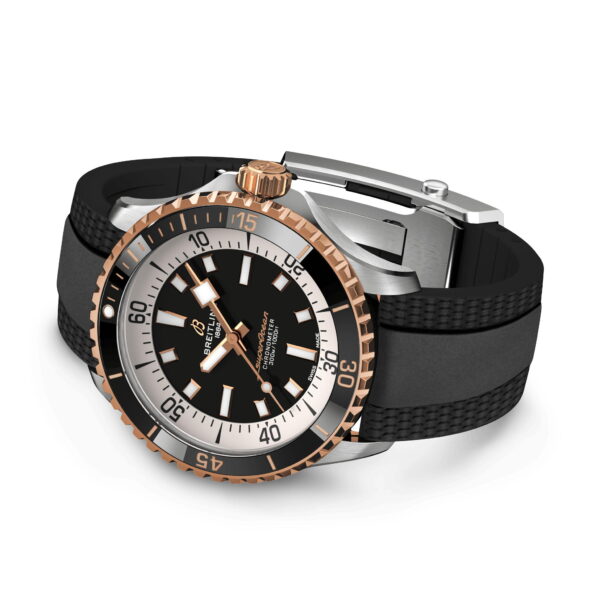 Die Armbanduhr Breitling Superocean III Automatik verfügt über ein schwarzes Zifferblatt mit weißen Stundenmarkierungen, eine Lünette aus Roségold, große Leuchtzeiger und wird mit einem schwarzen Kautschukarmband und Metallschließe geliefert.