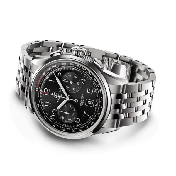 Der Breitling Premier B01 Chronograph ist eine Edelstahluhr mit schwarzem Zifferblatt, drei Hilfszifferblättern, einem Datumsfenster, silbernen Stundenmarkierungen und einer Tachymeterskala auf der Lünette, ergänzt durch ein Gliederarmband aus Metall.