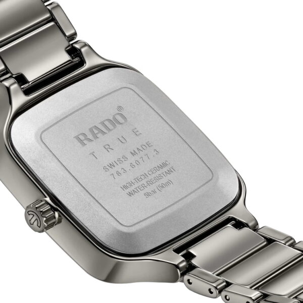 Das Bild zeigt die Rückseite einer Rado True Square Automatikuhr mit einem Rechteck mit abgerundeten Kanten und einem Edelstahlarmband. Zu den Gravuren gehören das Rado-Logo, „Swiss Made“ und die technischen Daten. Die Uhr verfügt über eine Faltschließe.