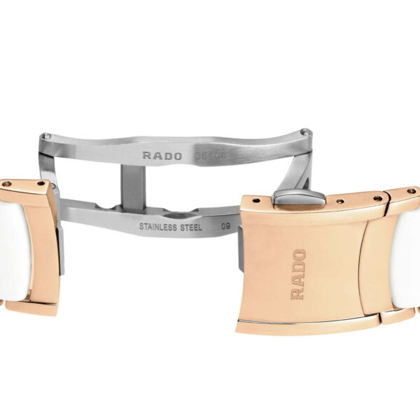 Nahaufnahme eines Rado Centrix Automatic Diamonds-Uhrenverschlusses im zweifarbigen Design mit Roségold- und weißen Keramikgliedern. Der Metallverschluss ist mit den Gravuren „RADO“ und „STAINLESS STEEL“ versehen.