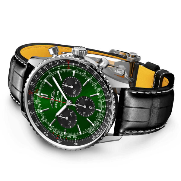Der Navitimer B01 Chronograph 46 besticht durch ein grünes Zifferblatt mit drei schwarzen Hilfszifferblättern, ein schwarzes Lederarmband mit gelbem Futter und eine silberne Lünette. Er verfügt über mehrere Markierungen, silberne Zeiger und das Markenlogo unter der 12-Uhr-Position.