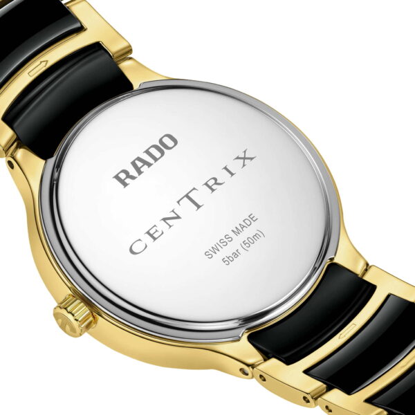 Nahaufnahme der Rückseite einer Rado Centrix Diamonds Uhr mit den Gravuren „RADO CENTRIX“, „SWISS MADE“ und „5 bar (50 m)“. Die Uhr verfügt über ein gold-schwarzes Gliederarmband.