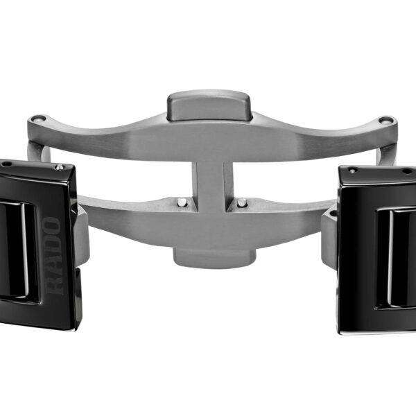 Nahaufnahme einer Rado True Square Thinline-Uhrschließe mit Schmetterlings-Faltmechanismus. Das glänzende schwarz-metallische Finish der eleganten Schließe und Glieder wird durch dezentes Branding akzentuiert.