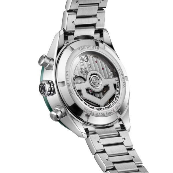 Der TAG Heuer Carrera Chronograph präsentiert sich von hinten und lässt durch sein transparentes Gehäuse die komplexen mechanischen Uhrwerke sichtbar werden. Er verfügt über ein Edelstahlarmband mit polierter Oberfläche und eingraviertem Text am Gehäuserand.