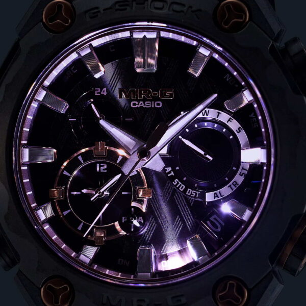 Nahaufnahme einer Casio G-Shock Pro Limited Edition MRG-B2000JS-1AD-Uhr mit schwarzem Zifferblatt, auffälligen beleuchteten Zeigern und Stundenmarkierungen, mehreren Hilfszifferblättern und strukturierter Oberfläche in einem robusten dunklen Gehäuse.