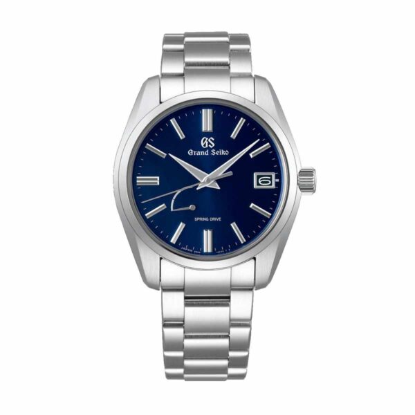 Die Grand Seiko Heritage ist eine silberne Armbanduhr mit blauem Zifferblatt, silbernen Stundenmarkierungen und einem Datumsfenster bei 3 Uhr. Sie verfügt über ein Edelstahlarmband und trägt den Schriftzug „Spring Drive“ auf dem Zifferblatt.