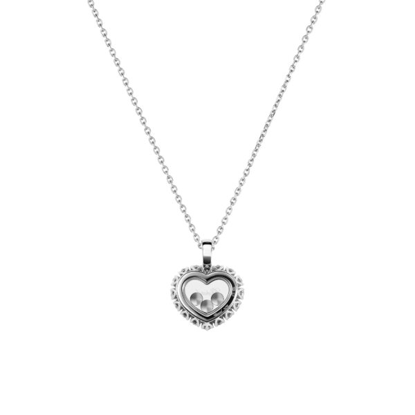 Das Chopard Happy Diamonds Collier ist eine Silberkette mit einem herzförmigen Anhänger mit komplizierten Details und drei kleinen Silberkugeln im Inneren vor einem schlichten weißen Hintergrund.