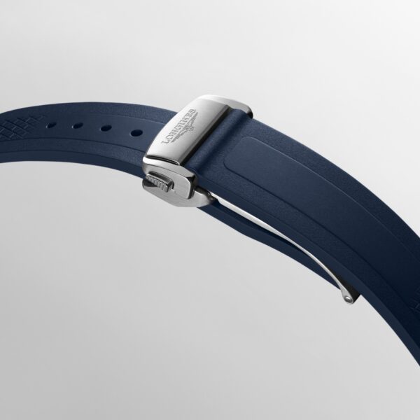 Eine Nahaufnahme des blauen Kautschukarmbands der Longines Conquest mit einer silbernen Faltschließe mit eingraviertem Markenlogo, dargestellt vor einem schlichten hellen Hintergrund.