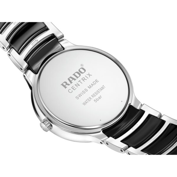 Nahaufnahme der Rückseite einer Rado Centrix Diamonds-Armbanduhr mit Edelstahlgehäuse, schwarzen Keramikgliedern und einer Gravur: „RADO CENTRIX SWISS MADE WATER RESISTANT 5 bar.“.