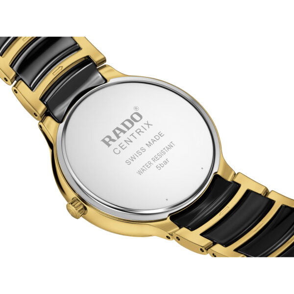 Nahaufnahme der Rückseite einer Rado Centrix Diamonds Armbanduhr mit gold-schwarzem Metallarmband. Auf dem Edelstahlgehäuseboden ist eingraviert: „RADO CENTRIX SWISS MADE WATER RESISTANT 5 bar“.