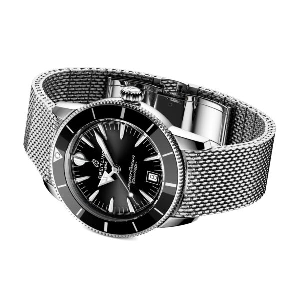 Die Breitling Superocean Heritage B31 Automatic 40 verfügt über ein schwarzes Zifferblatt, silberne Stundenmarkierungen, ein Datum bei 3 Uhr und ein silbernes Metallarmband aus Mesh, das schräg auf weißem Hintergrund angezeigt wird.