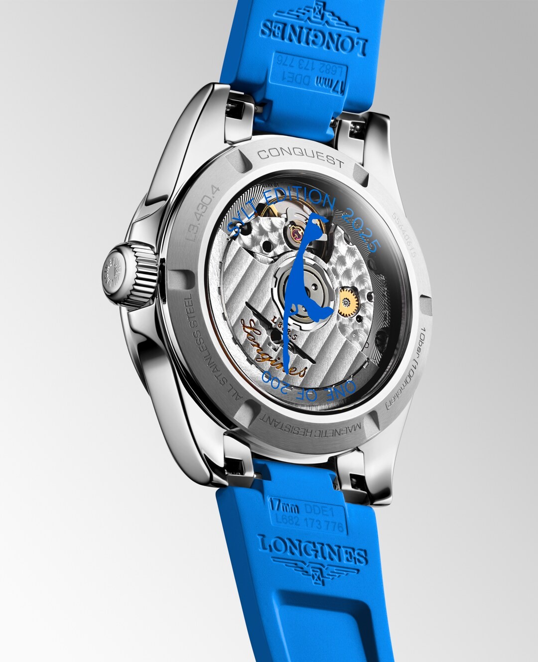 Eine Nahaufnahme des Uhrenbodens der Longines Conquest offenbart das mechanische Uhrwerk, die gravierten Details und die Zahnräder durch einen transparenten Gehäuseboden, ergänzt durch ein leuchtend blaues Silikonarmband.
