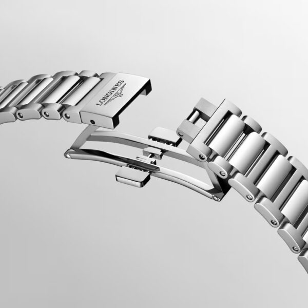 Eine Nahaufnahme des silbernen Longines Conquest-Metallarmbandes mit teilweise geöffneter Schmetterlingsschließe und eingraviertem Longines-Logo vor einem schlichten hellgrauen Hintergrund.