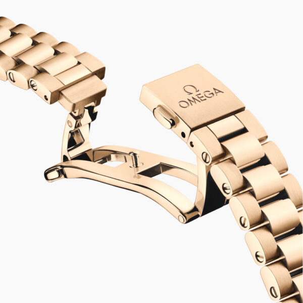 Nahaufnahme eines geöffneten OMEGA Seamaster Aqua Terra 150M Goldarmbandes mit Faltschließe. Das eingravierte Omega-Logo und der Name erscheinen auf der Schließe, und das Armband zeigt polierte Glieder mit sichtbaren Schrauben.