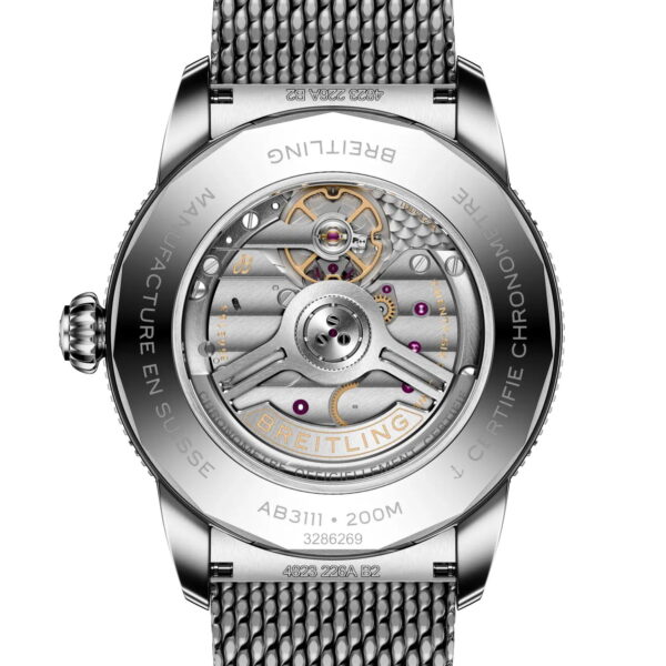 Nahaufnahme des transparenten Gehäusebodens der Breitling Superocean Heritage B31 Automatic 42, der das komplizierte mechanische Uhrwerk, den eingravierten Metallrandtext, die beschrifteten Komponenten und das sichtbare gewebte Metallarmband zeigt.