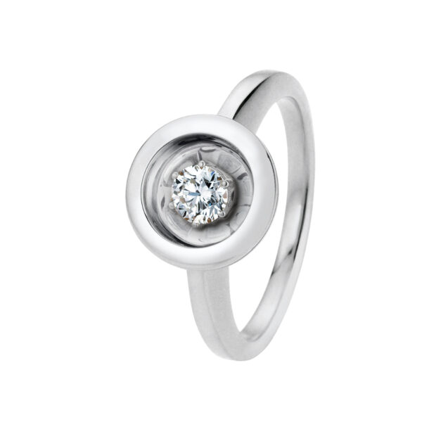 Der Jörg Heinz Swing Ring Weite 54 ist ein Silberring mit einem schlanken, modernen Design. In der Mitte befindet sich ein runder, gefasster Diamant, der von einem glatten, polierten Metallrand umgeben ist.
