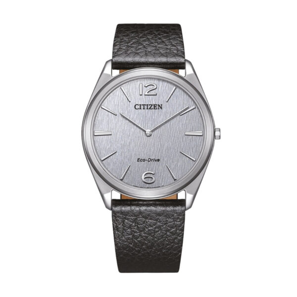 Die Citizen Eco-Drive Suratto verfügt über ein silbernes strukturiertes Zifferblatt mit minimalistischen Indexen, silbernen Zeigern und einem schwarzen Lederarmband. Das Zifferblatt zeigt das Citizen-Logo und den Schriftzug "Eco-Drive".