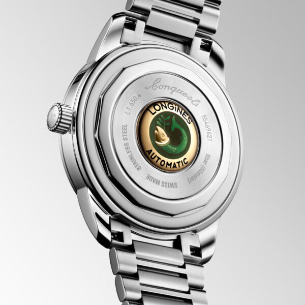 Eine Nahaufnahme der Rückseite einer Longines Conquest Heritage Armbanduhr. Hervorzuheben sind das Edelstahlgehäuse und -armband, der sichtbare Markenrotor und die detaillierten Gravuren am Gehäuseboden.