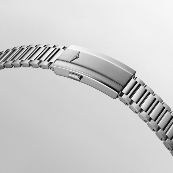 Eine Nahaufnahme des Edelstahlarmbands der Longines Conquest Heritage mit einer sicheren Faltschließe und einem kleinen eingravierten Logo vor einem schlichten hellgrauen Hintergrund.