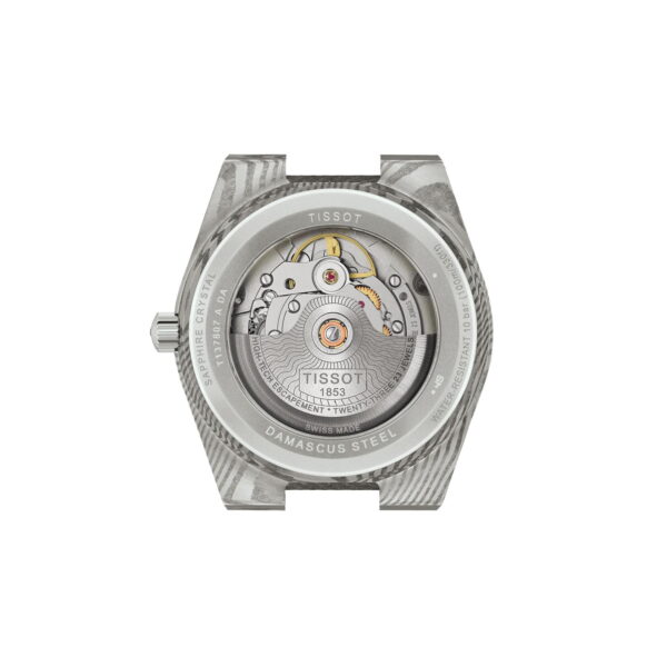 Eine Nahaufnahme des Gehäusebodens der Tissot PRX Damascus Steel, die aus Damaszenerstahl gefertigt ist. Das transparente Saphirglas gibt den Blick auf das mechanische Uhrwerk und die eingravierten Details frei.
