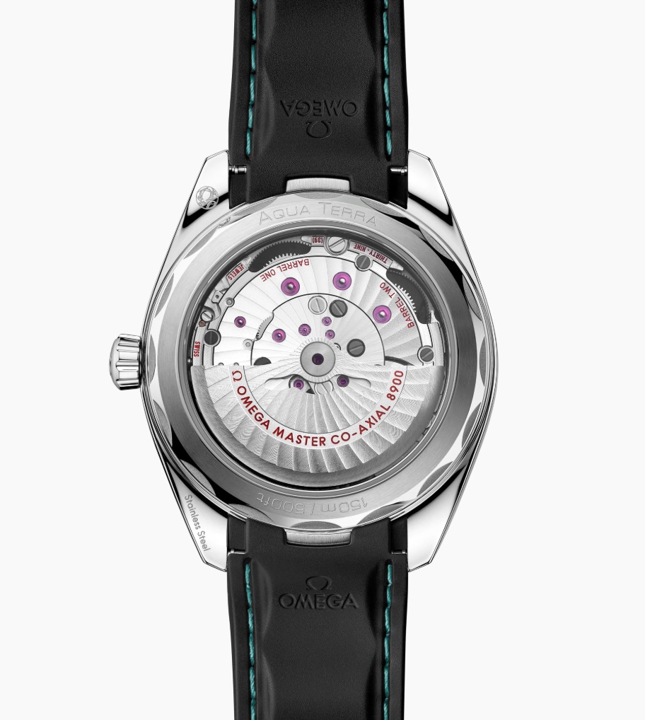 Die Rückansicht der OMEGA Seamaster Aqua Terra 150M zeigt ihr offenes mechanisches Uhrwerk durch einen transparenten Gehäuseboden. Sichtbare Zahnräder und Gravuren sind zu sehen, gepaart mit einem schwarzen Lederarmband mit blauen Nähten.