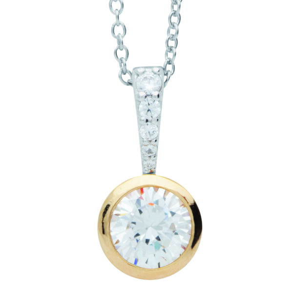 Eine Nahaufnahme der Classic Solitaire Halskette Charming: ein goldener Anhänger mit rundem Diamanten in Lünettenfassung an einer silbernen Kette, mit zusätzlichen kleinen Diamanten im Bügel.