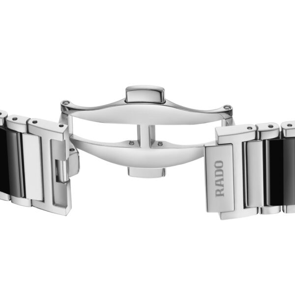 Eine Nahaufnahme des silbernen Uhrenarmbands der Rado Integral mit polierten Metallgliedern, einer offenen Schmetterlingsschließe und dem eingravierten Rado-Logo auf einer Seite.