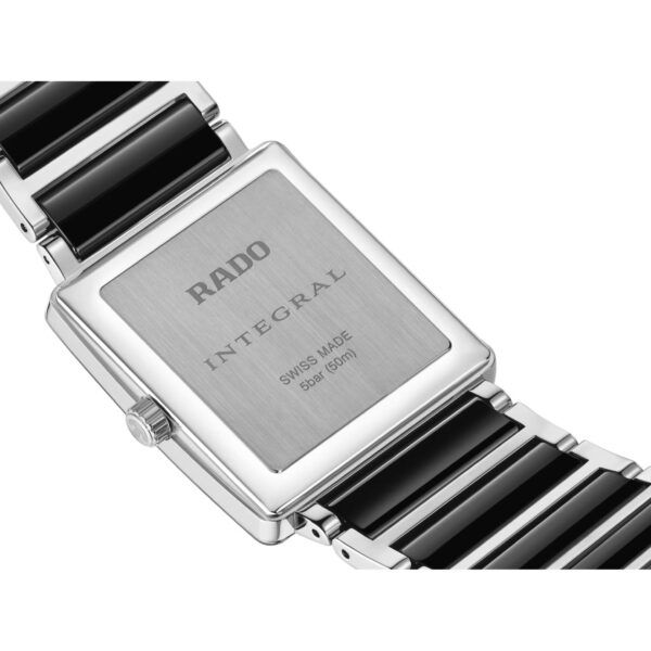 Nahaufnahme der Rückseite der Rado Integral Armbanduhr mit einem Edelstahlgehäuse, schwarzen Keramikgliedern und einer gravierten Rückwand mit der Aufschrift RADO INTEGRAL SWISS MADE 50M (5BAR)".