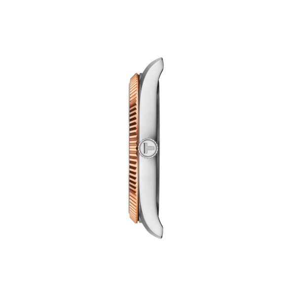 Seitenansicht der Tissot Ballade 40-mm-Armbanduhr mit silbernem Gehäuse und geriffelter Lünette aus Roségold. Die zentrierte Krone zeigt das "T"-Logo vor einem schlichten weißen Hintergrund.