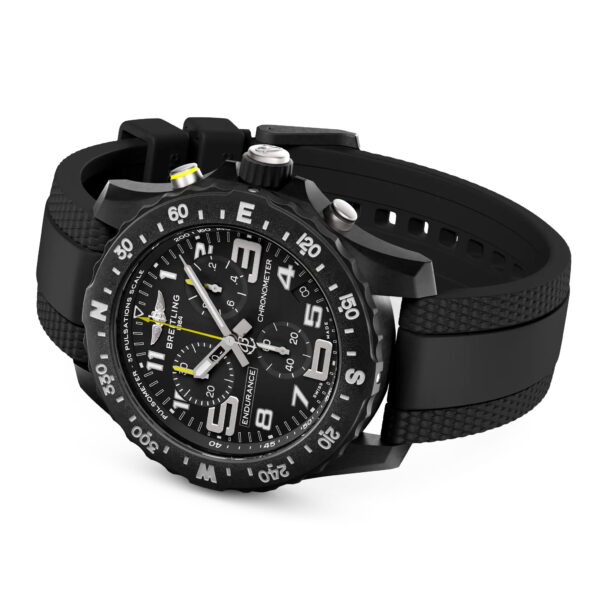 Die Breitling Endurance Pro 44 ist ein schwarzer Chronograph mit einem strukturierten schwarzen Kautschukband, auffälligen weißen Ziffern und Markierungen auf der Lünette und dem Zifferblatt, einer Datumsanzeige und einem Chronographenzeiger mit gelber Spitze.