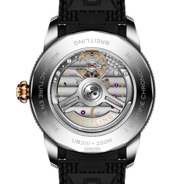 Nahaufnahme des transparenten Gehäusebodens einer Breitling Superocean Heritage B31 Automatic 42, die das komplizierte mechanische Uhrwerk, die sichtbaren Zahnräder, den gravierten Randtext und die metallischen Details zeigt. Die Uhr ist mit einem schwarzen Armband ausgestattet.