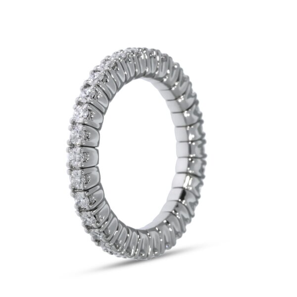 Der Scheffel Stretch Griff Damenring ist ein silberner Ewigkeitsring mit einer Reihe kleiner, runder Diamanten, die das Band umschließen und aufrecht vor einem weißen Hintergrund stehen.