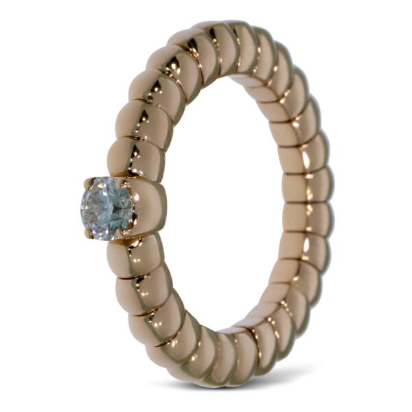 Der Scheffel Stretch Ring Solitair zeichnet sich durch ein geriffeltes, segmentiertes Goldband und einen einzelnen runden Solitärdiamanten aus, der aufrecht vor einem weißen Hintergrund steht.