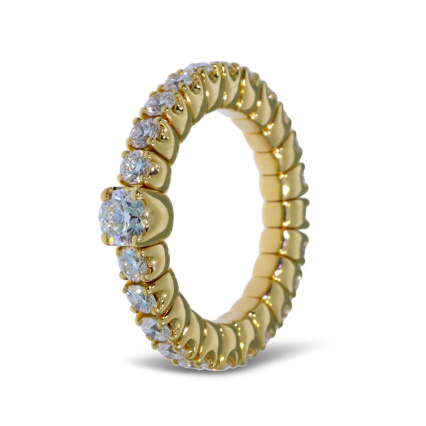 Der Scheffel Stretch Solitair Damenring, ein goldener Ewigkeitsring, der rundherum mit runden, funkelnden Diamanten besetzt ist, wird aufrecht auf weißem Hintergrund gezeigt.