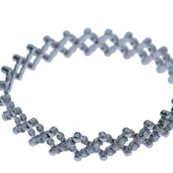 Der Ring/Armband von Serafino Consoli zeichnet sich durch ein sich wiederholendes X-förmiges Gliedermuster mit kleinen, funkelnden Steinen auf weißem Hintergrund aus.
