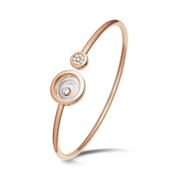 Der Chopard Happy Spirit Armreif ist ein zarter Armreif aus Roségold mit zwei runden Diamanten - ein größerer und ein kleinerer -, die jeweils von glatten Metallbändern umgeben sind, die vor einem weißen Hintergrund stehen.