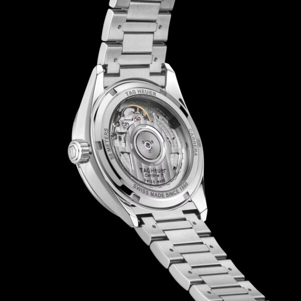 Nahaufnahme der Rückseite einer TAG Heuer Carrera Date mit Edelstahlarmband, mit transparentem Gehäuseboden und sichtbarem mechanischem Uhrwerk vor schwarzem Hintergrund.